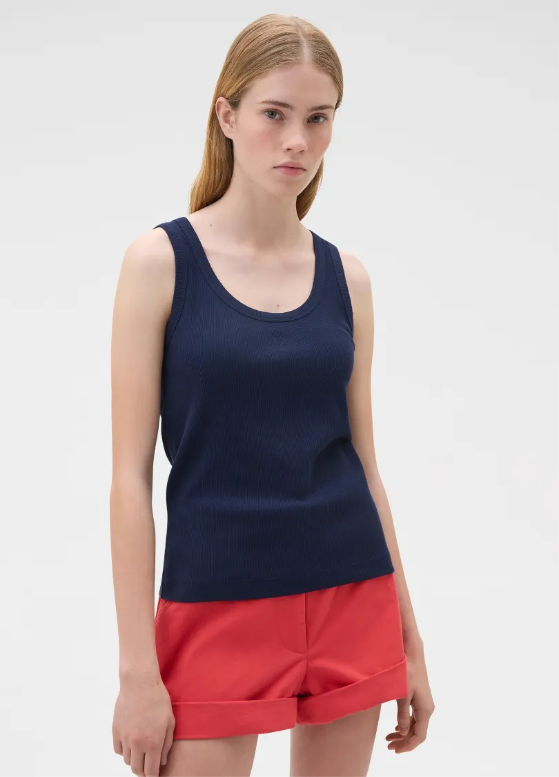 Model wearing a navy tank top and red shorts against a plain background.