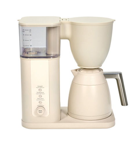 Coffee maker in cream color with glass carafe and water reservoir.