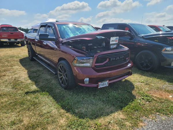 Maroon Ram 1500 with hood open on display at outdoor car show event