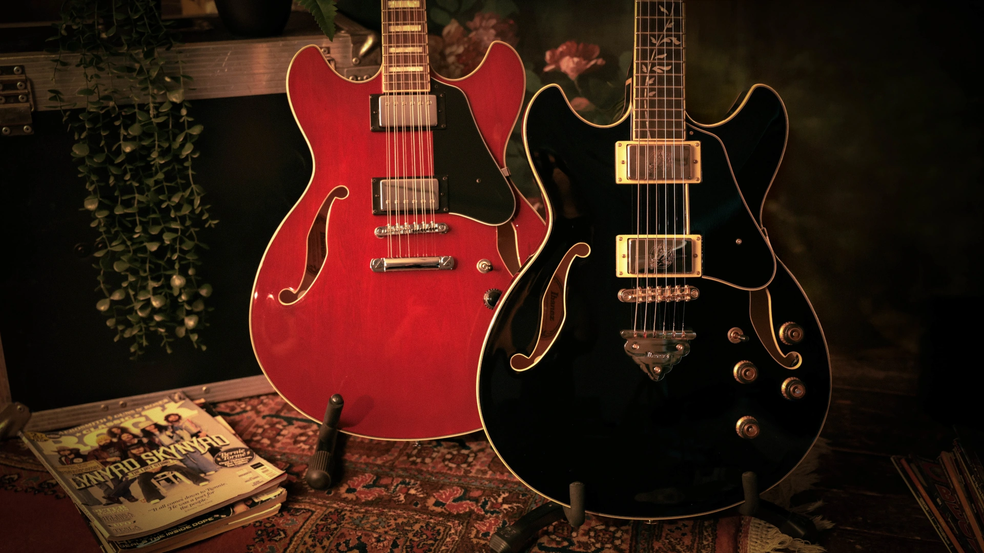 Two Ibanez Artcore guitars, one red and one black, on a decorative surface.