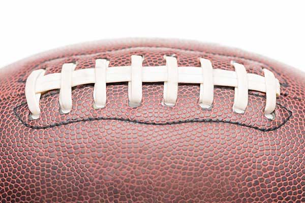 A close-up of a brown American football with laces.