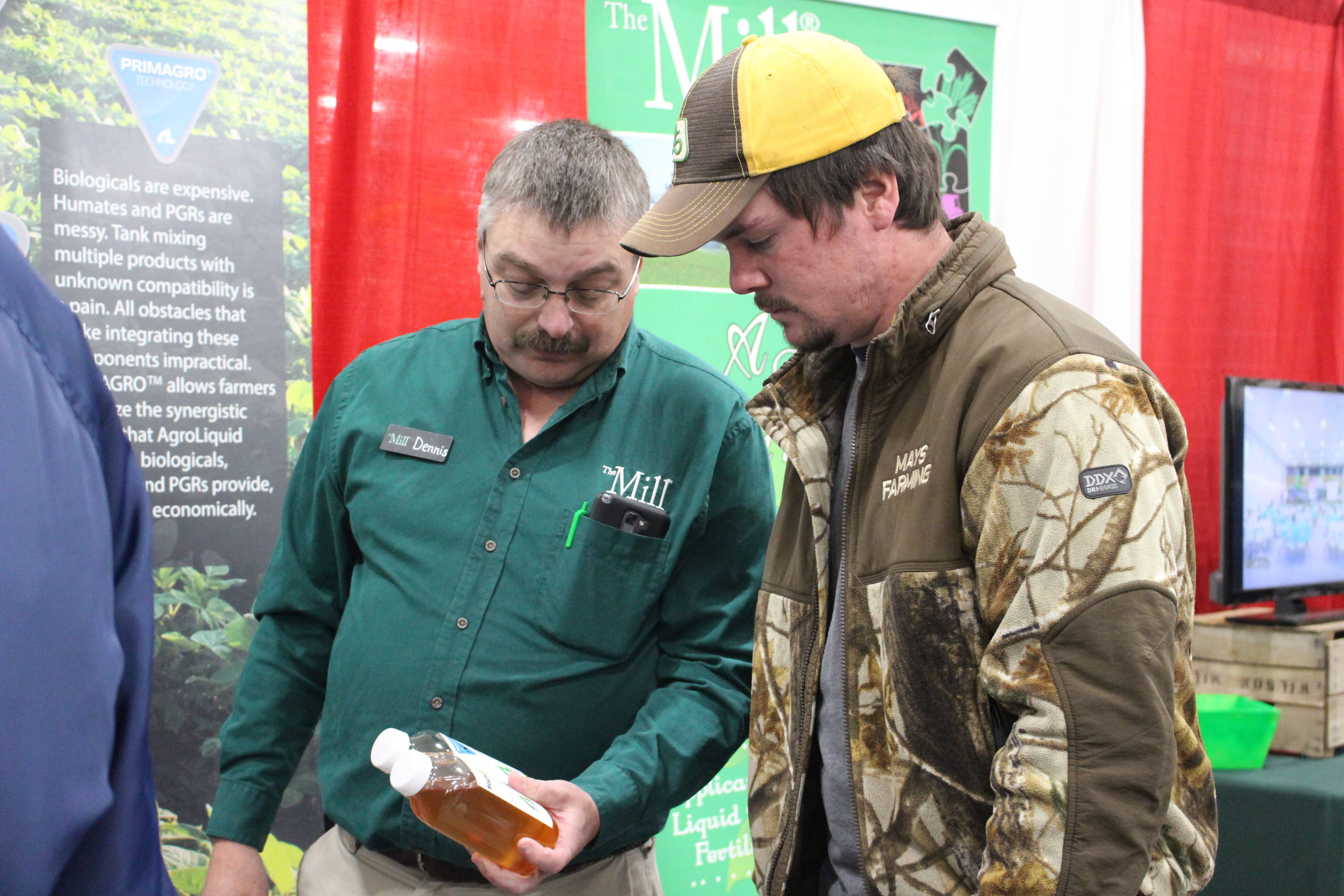 Agronomist and farmer looking at a product.