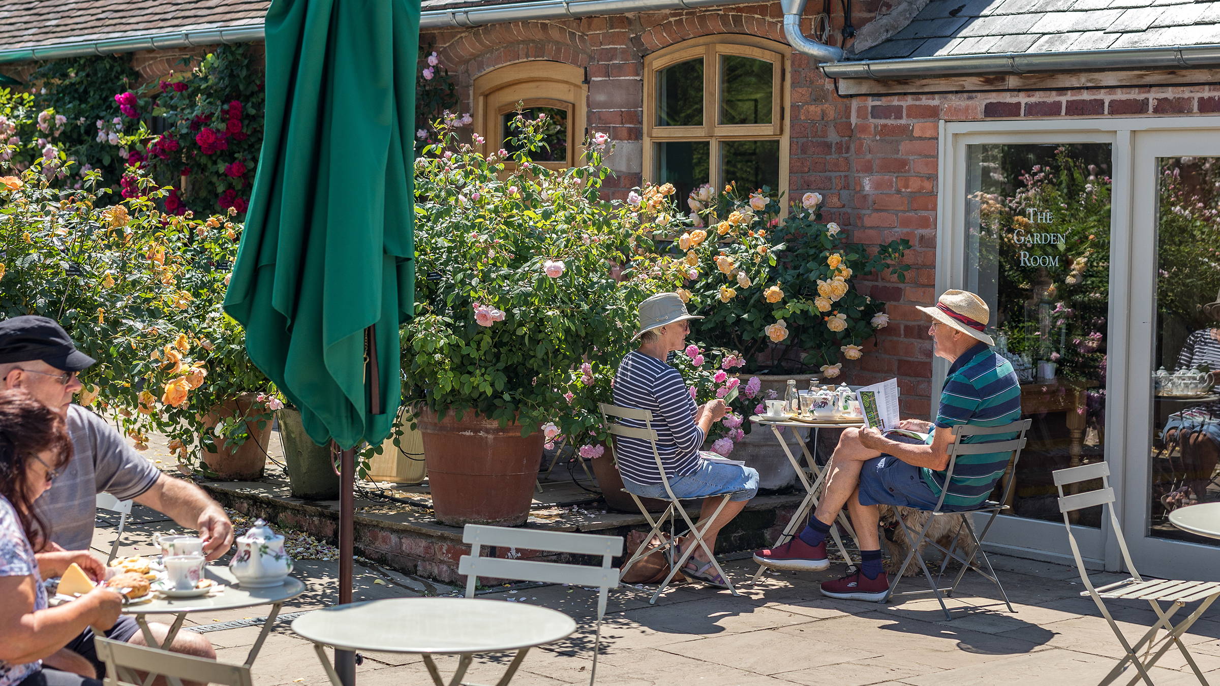  Leute sitzen an Tischen außerhalb des Garden Tea Room