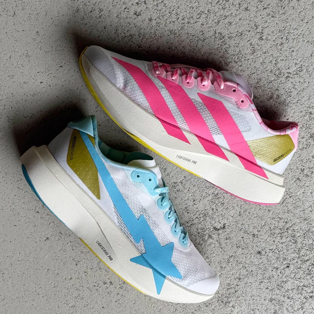 Two colorful athletic shoes, one pink and one blue, on a gray surface.