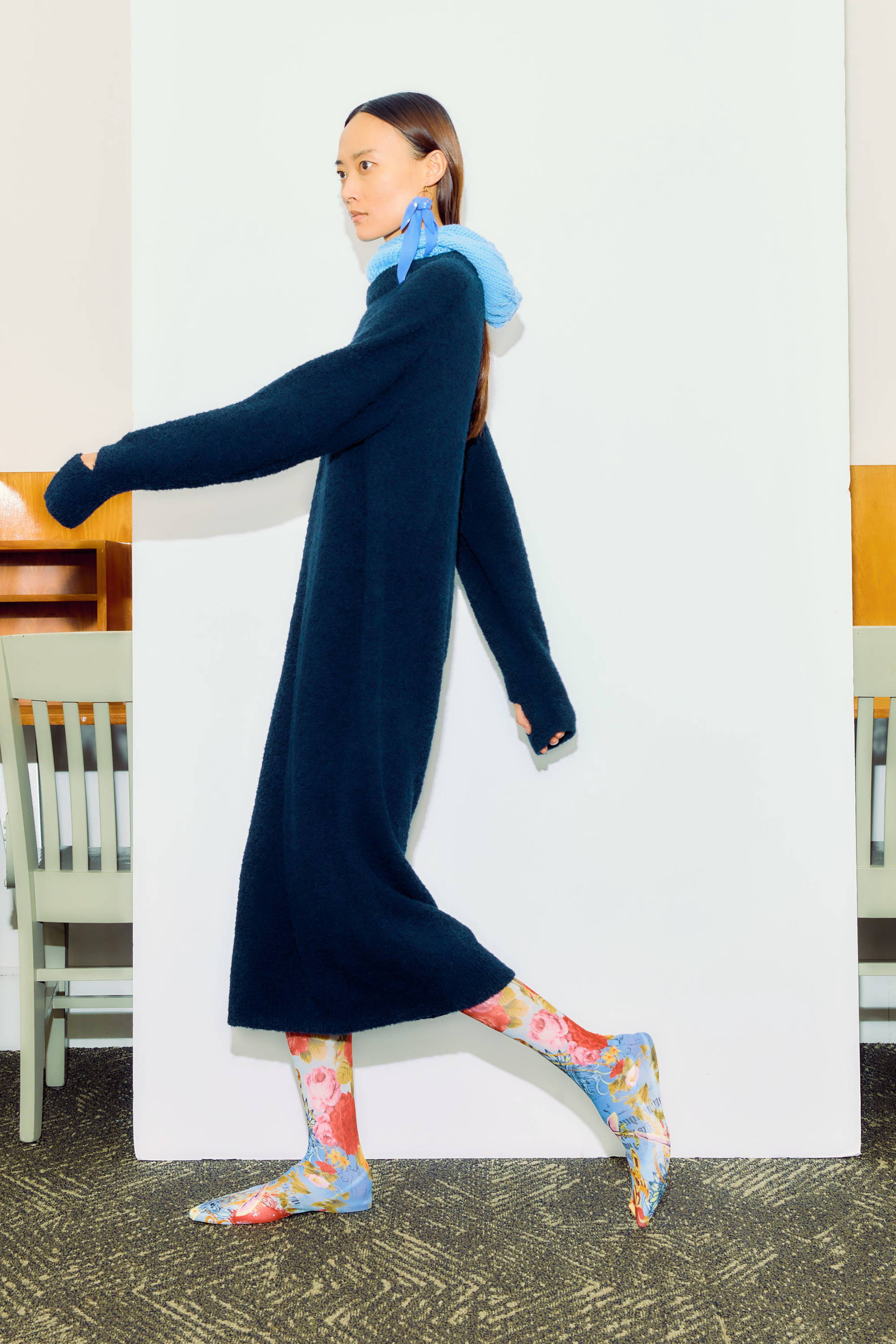 Model walking in a long dark dress and colorful socks.