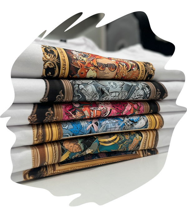 Stacked white folded garments with ornate and detailed prints featuring intricate patterns and artwork.