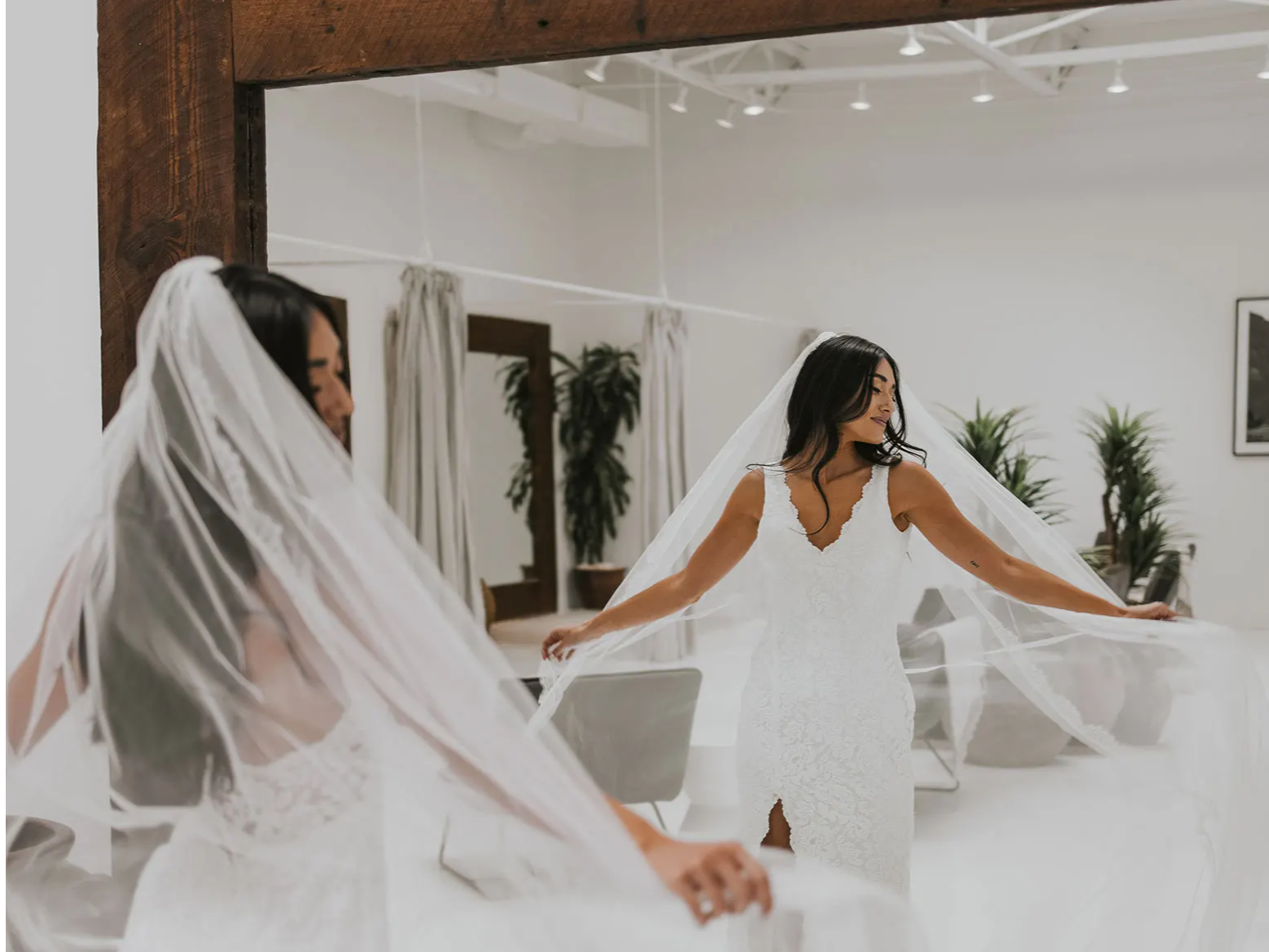Bride in the mirror wearing the Lumi wedding dress and Lumi veil 