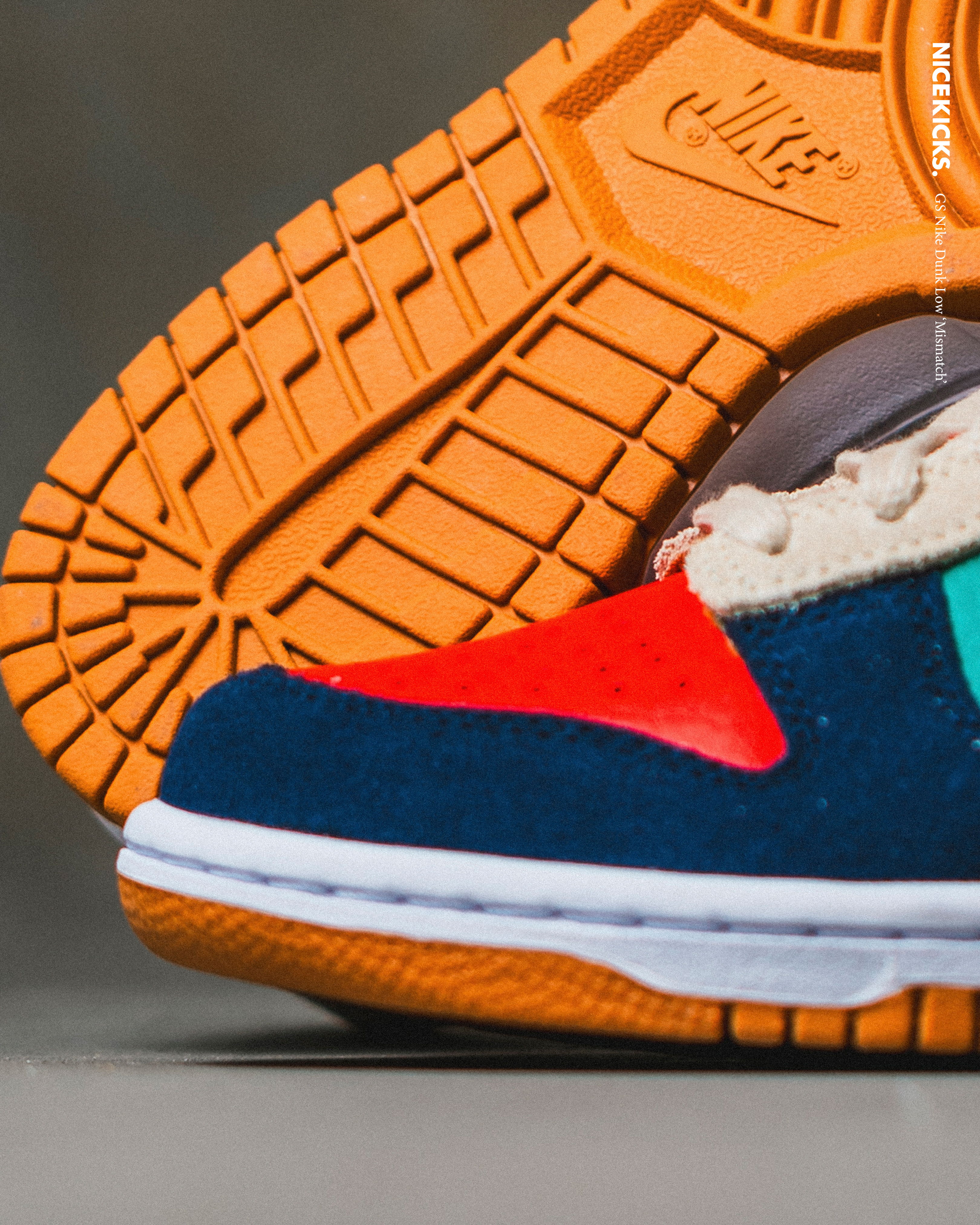 Colorful sneaker with orange sole and textured bottom view.
