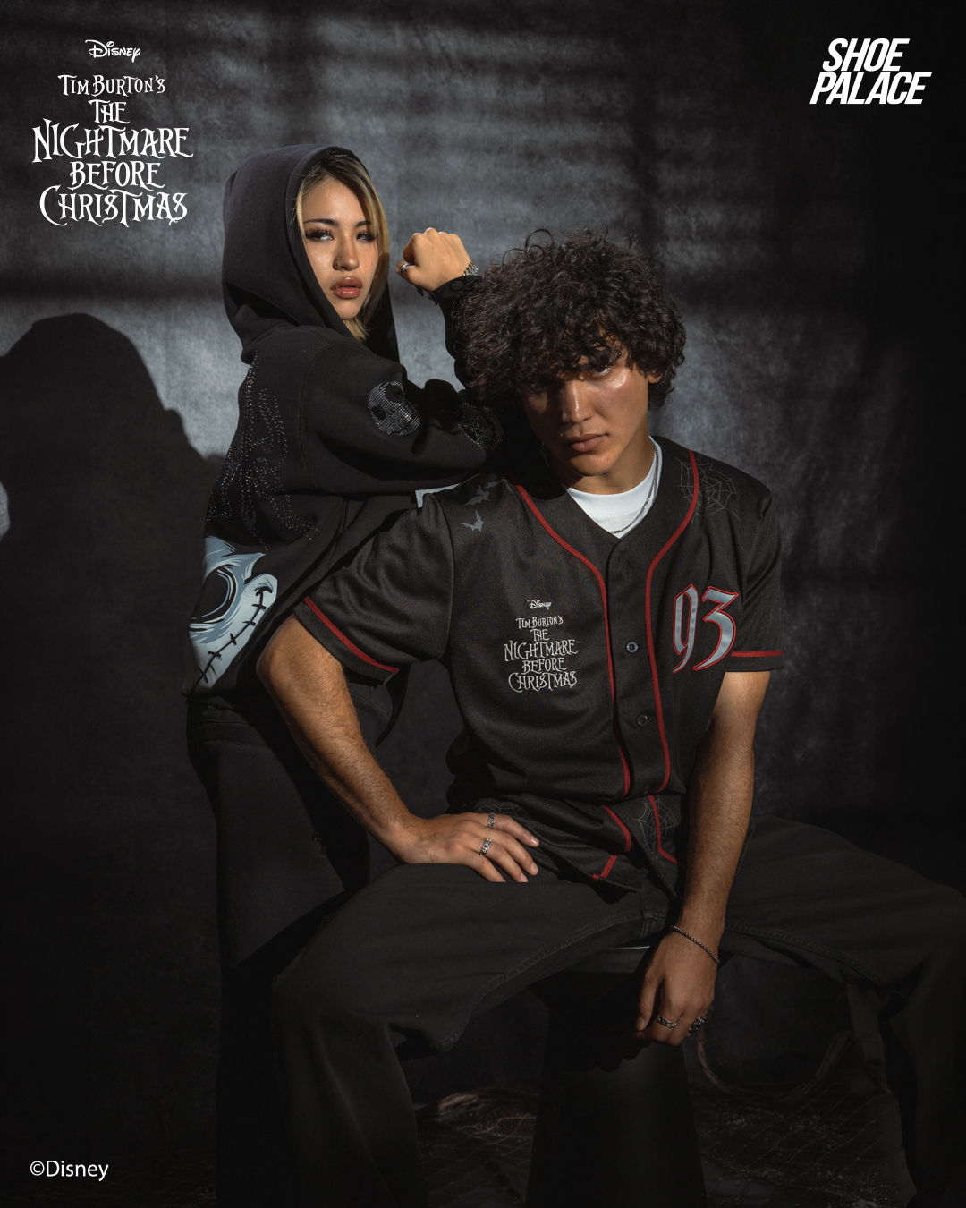 Two people posing in themed outfits, with a dark background.