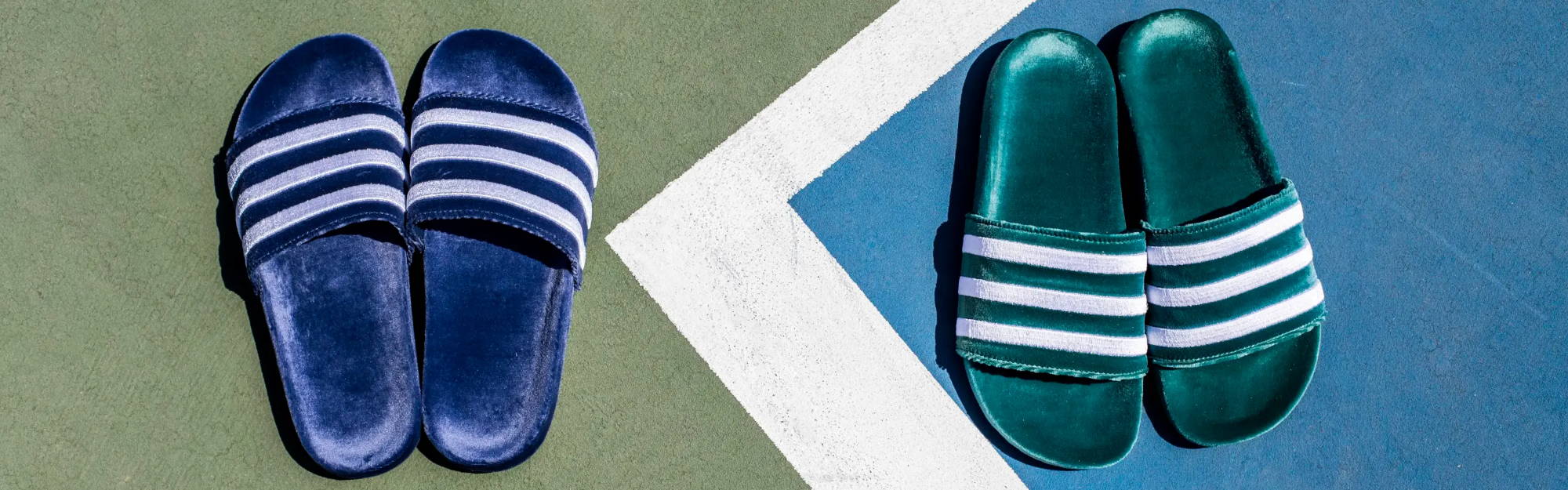 blue and green velvet adidas slides on tennis court 