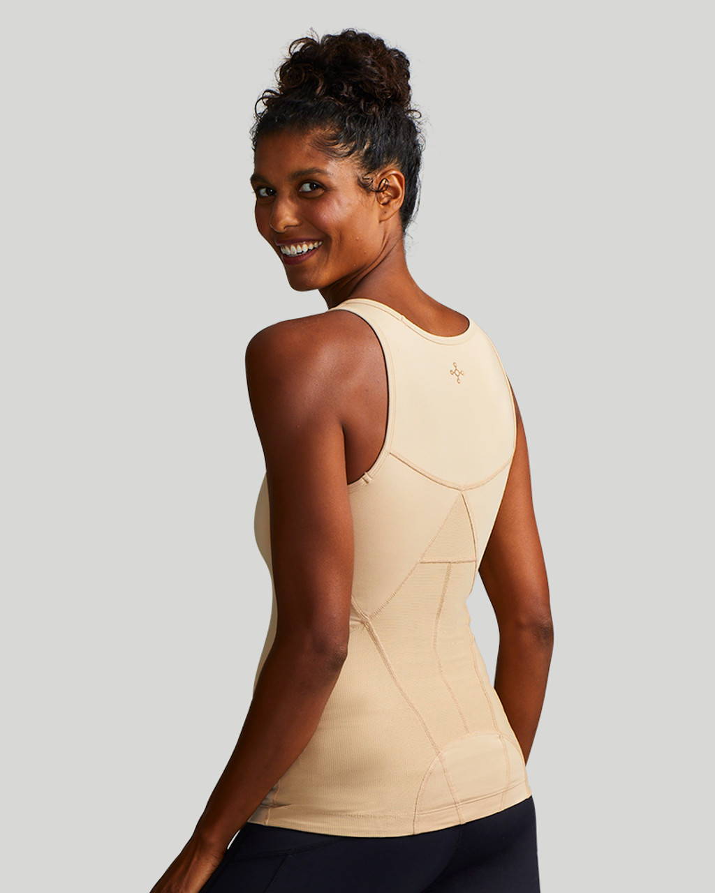 A woman wearing a natural Tommie Copper Lower Back Support Tank