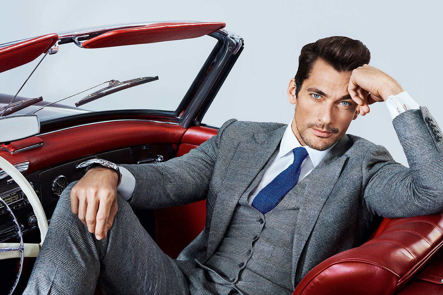 David Gandy Wearing A Grey Suit Sitting In A Red Convertible Car