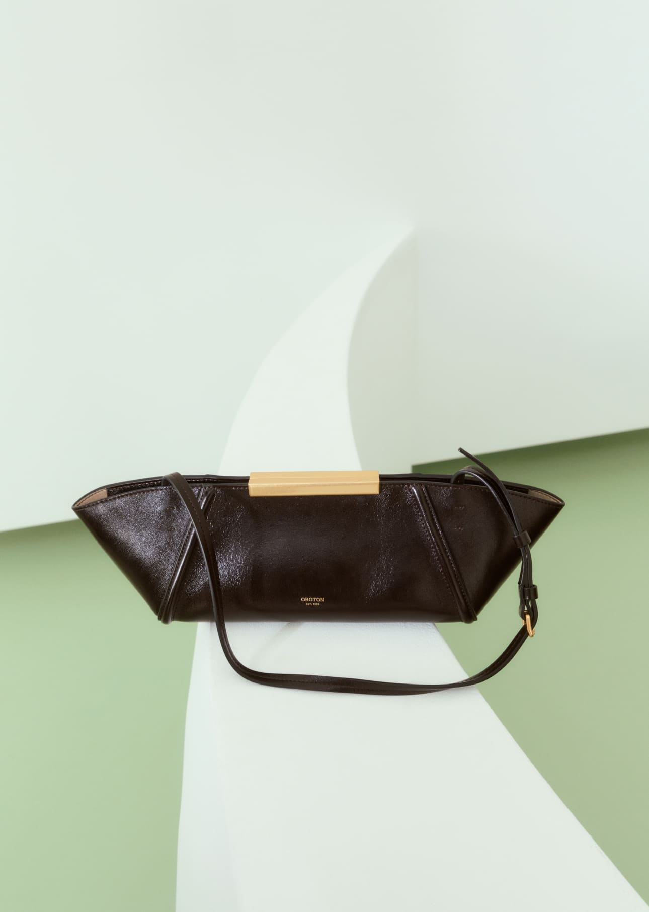 A stylish brown handbag on a minimalistic background.