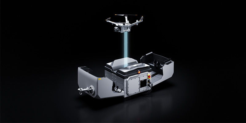 A DJI Matrice 5TD hovers over a DJI Dock 4 while a blue light demonstrates how data is transferred.