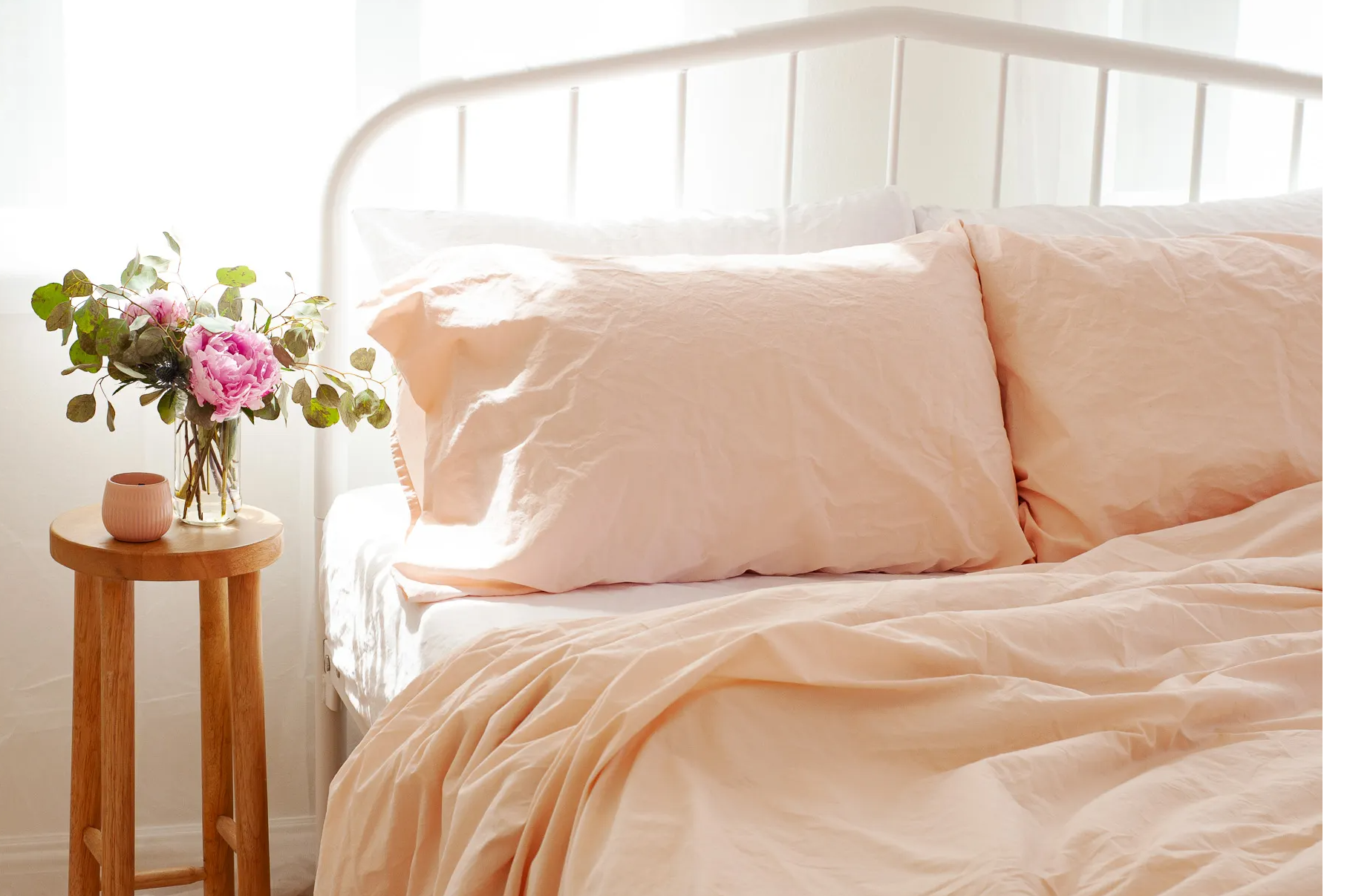 an airy bedroom scene displays a combination of the white and peach cinkle percale cotton sheet sets 