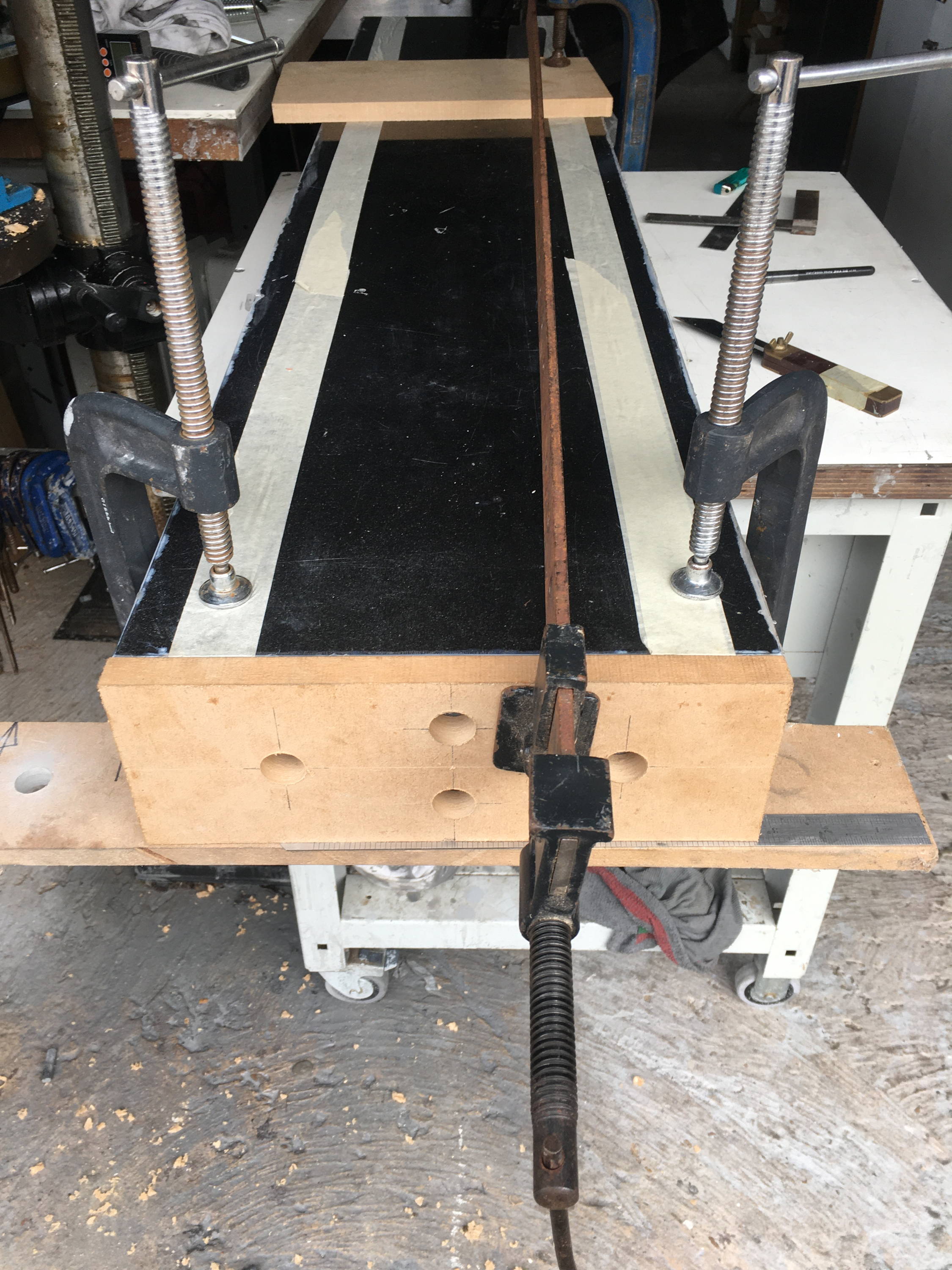Image of a driling jig for drilling the holes in the end of the granite block for cementing in M12 inserts.