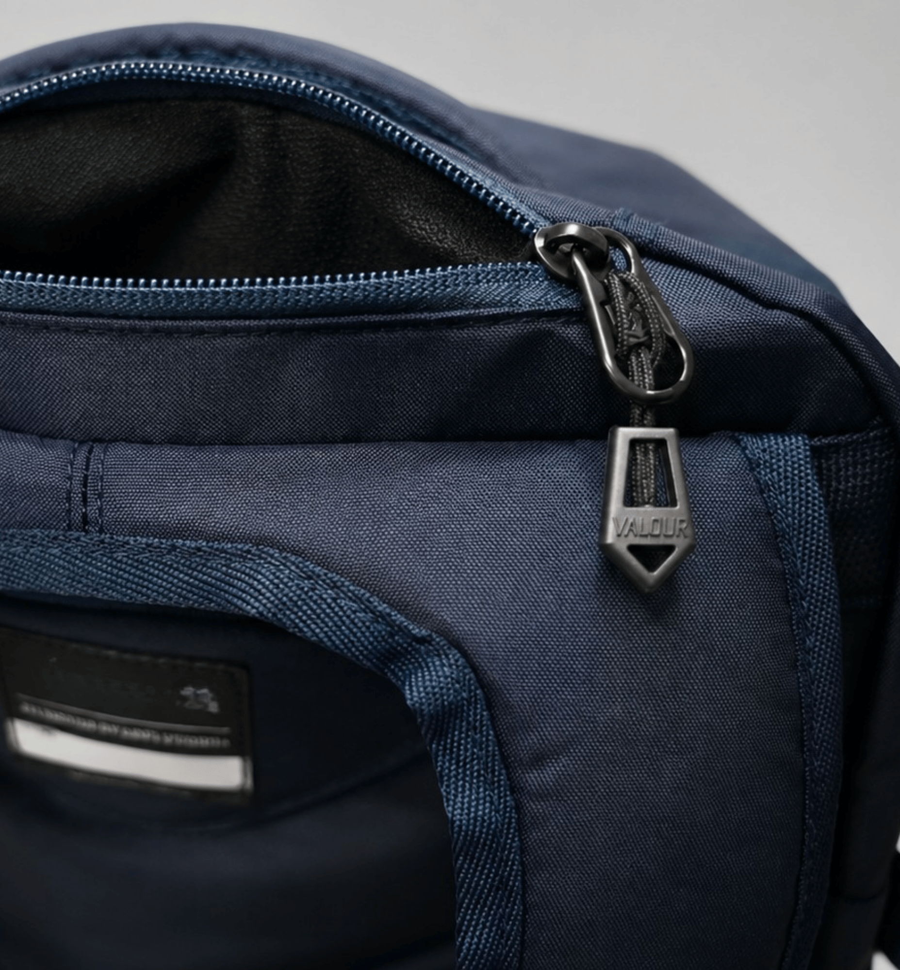 Close-up of a navy blue Valour Prestige backpack with a zipper.