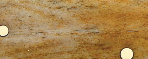 Close-up of a wooden surface with two round white objects.