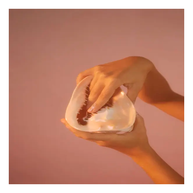 Mão feminina dentro de um objeto côncavo