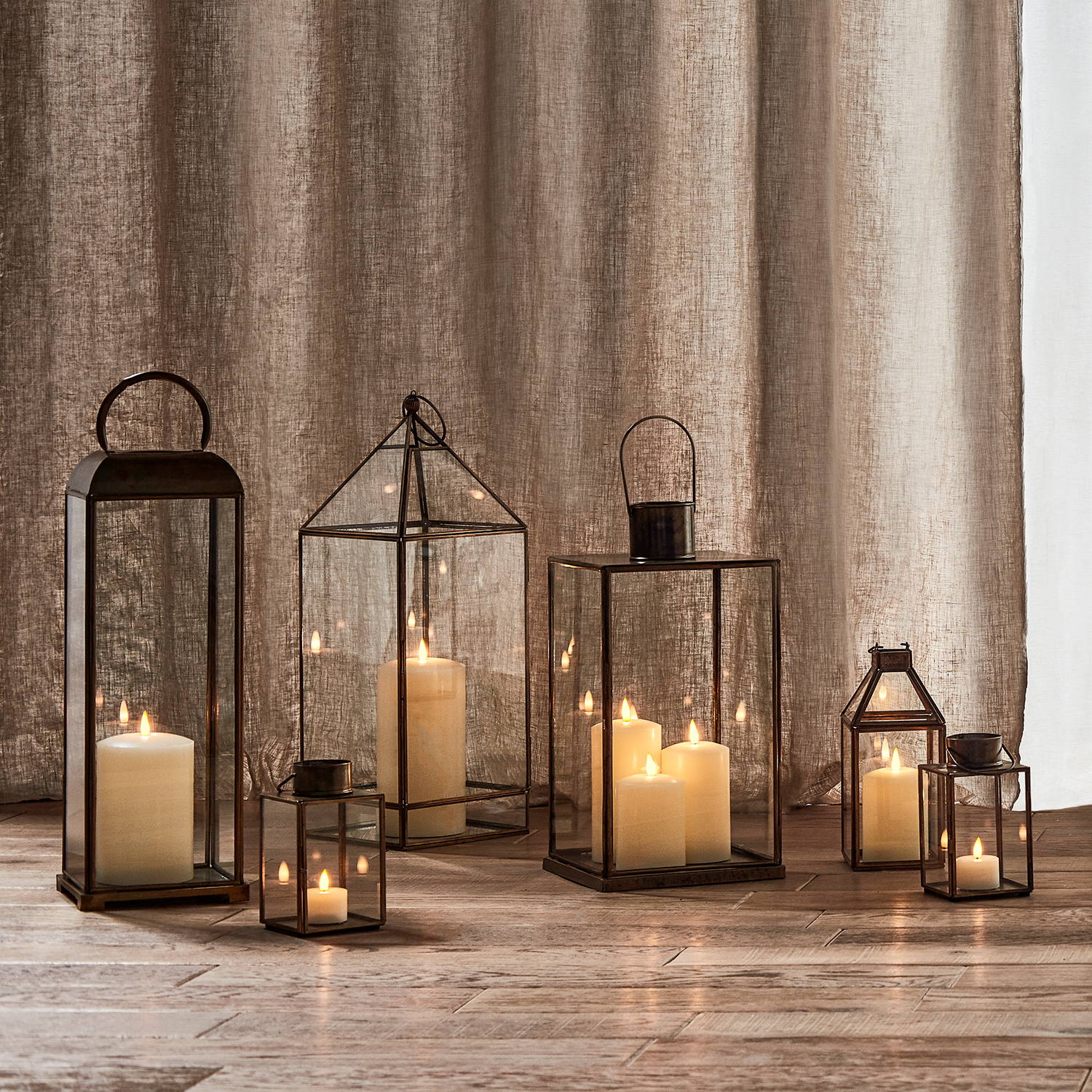 Assortment of indoor lanterns displayed on floor at varying heights