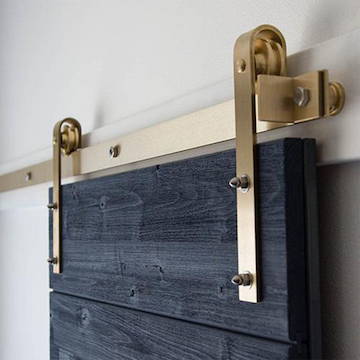 Brass Classic Sliding Barn Door Hardware Kit on weathered wood door
