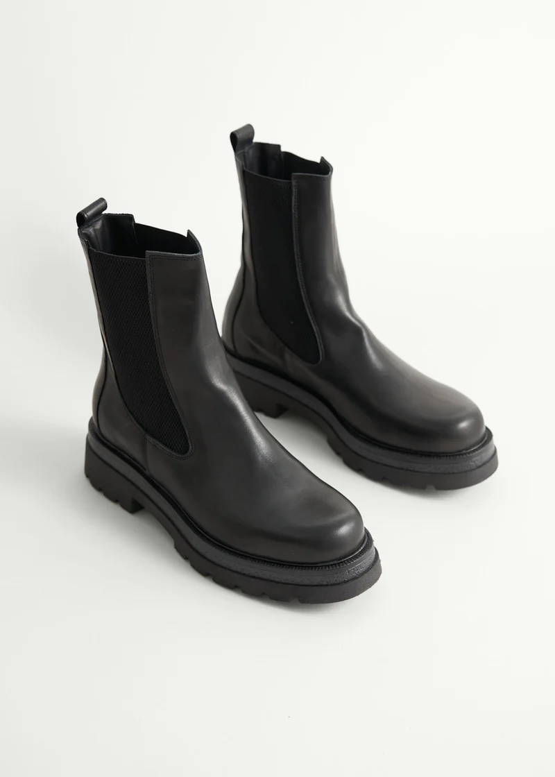 A pair of black leather high top chelsea boots