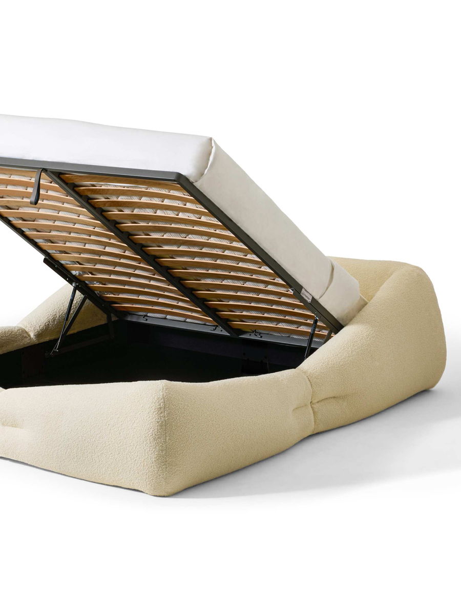 A modern Cassina bed with a unique design and patterned blanket.