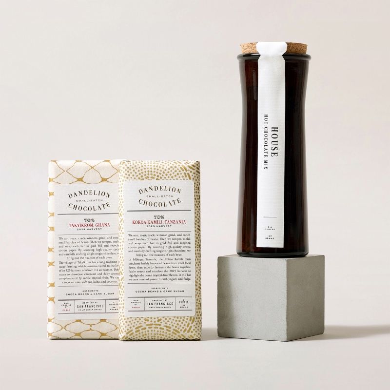 A bottle on a pedestal next to a package with text.