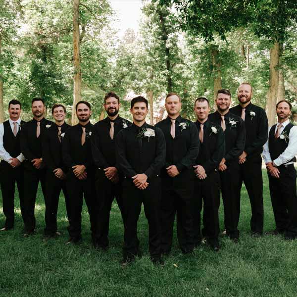 Grrom and groomsmen wearing variations of black and taupe