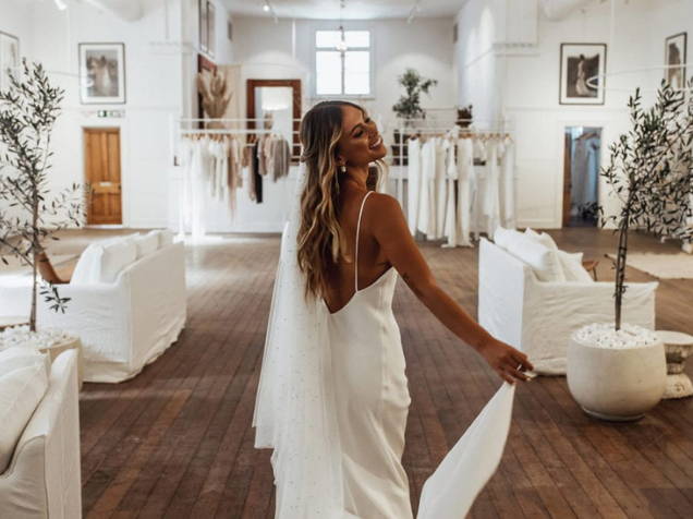 Suelos de madera encalada y sofás de lino blanco en la tienda de novias