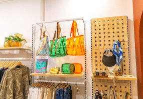 Colorful bags displayed on shelves in a retail store.