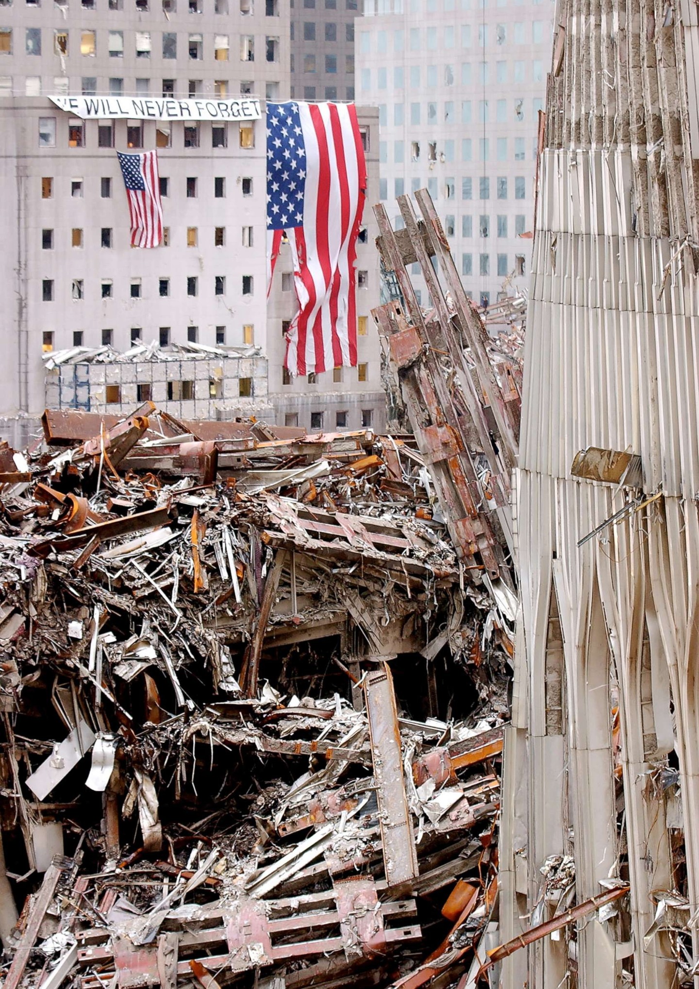 Destruction site with American flag and debris from collapsed buildings.