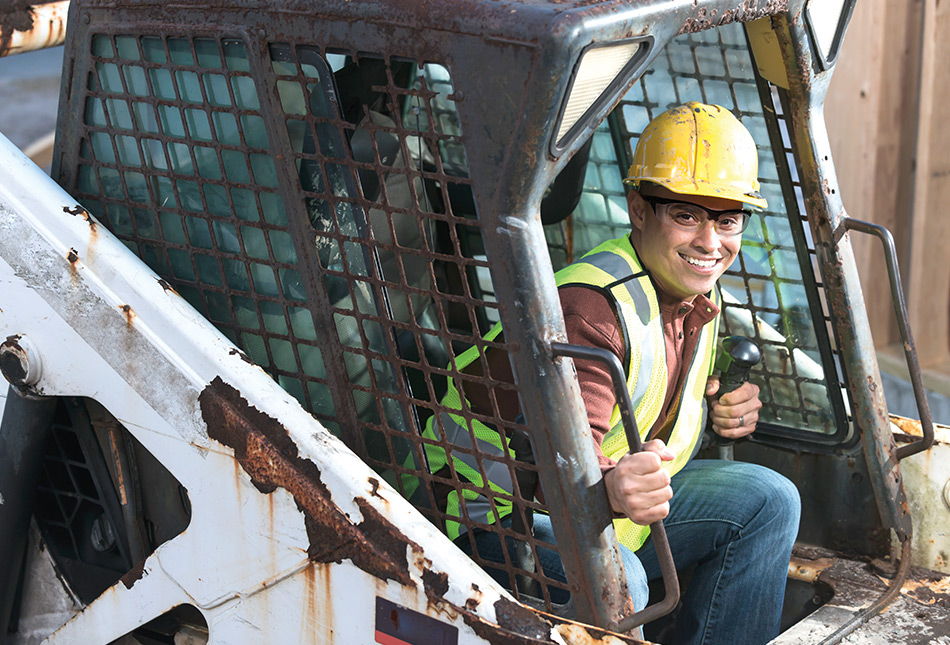 Person in a hard hat operating a construction vehicle.