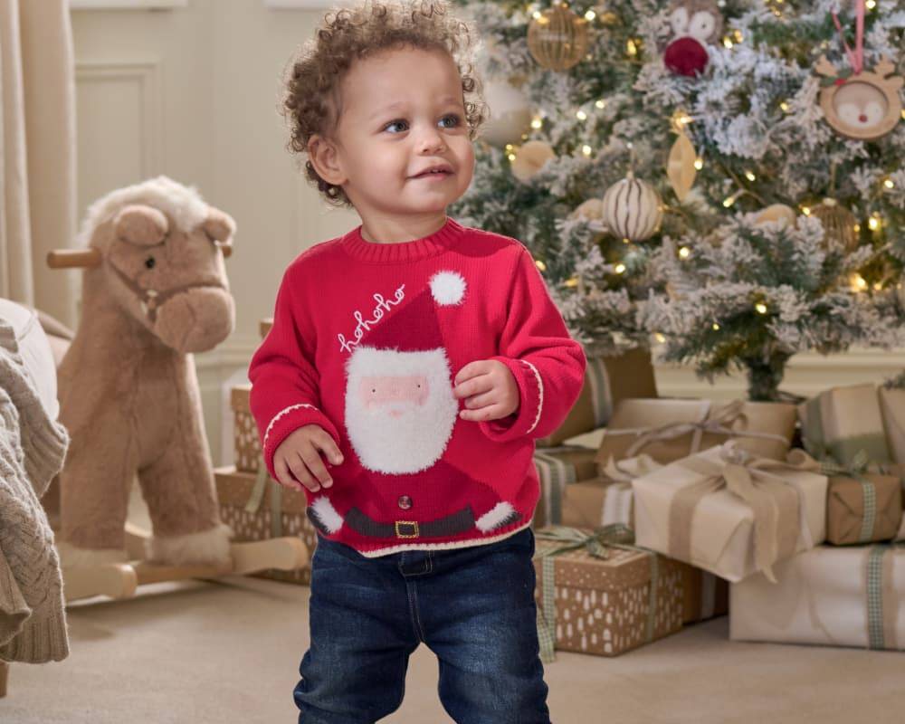 Smiling boy wearing santa Christmas jumper