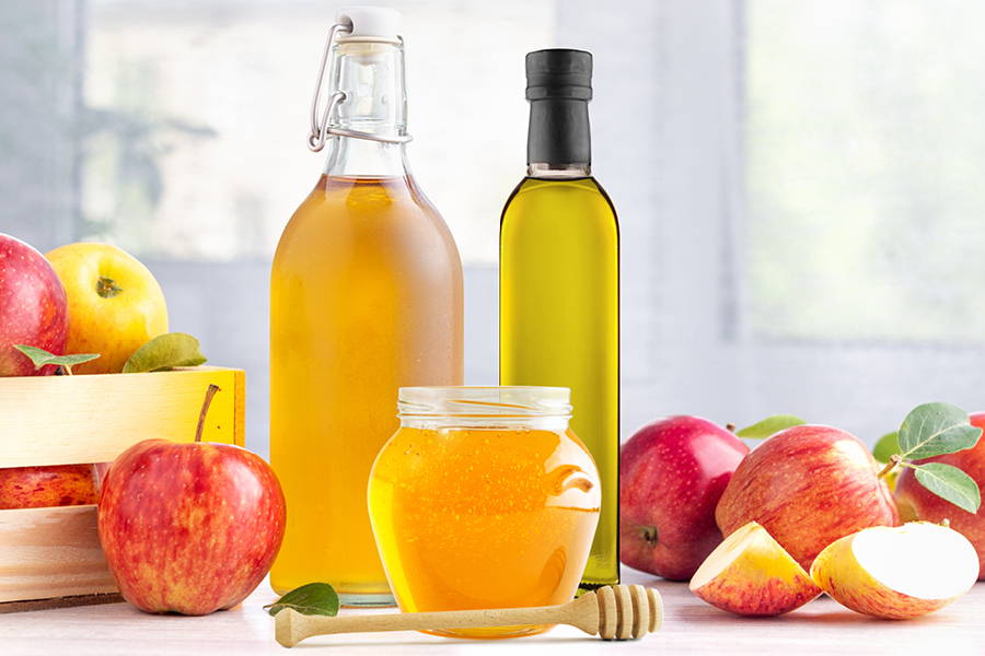honey apple cider vinegar and olive oil bottles with apples