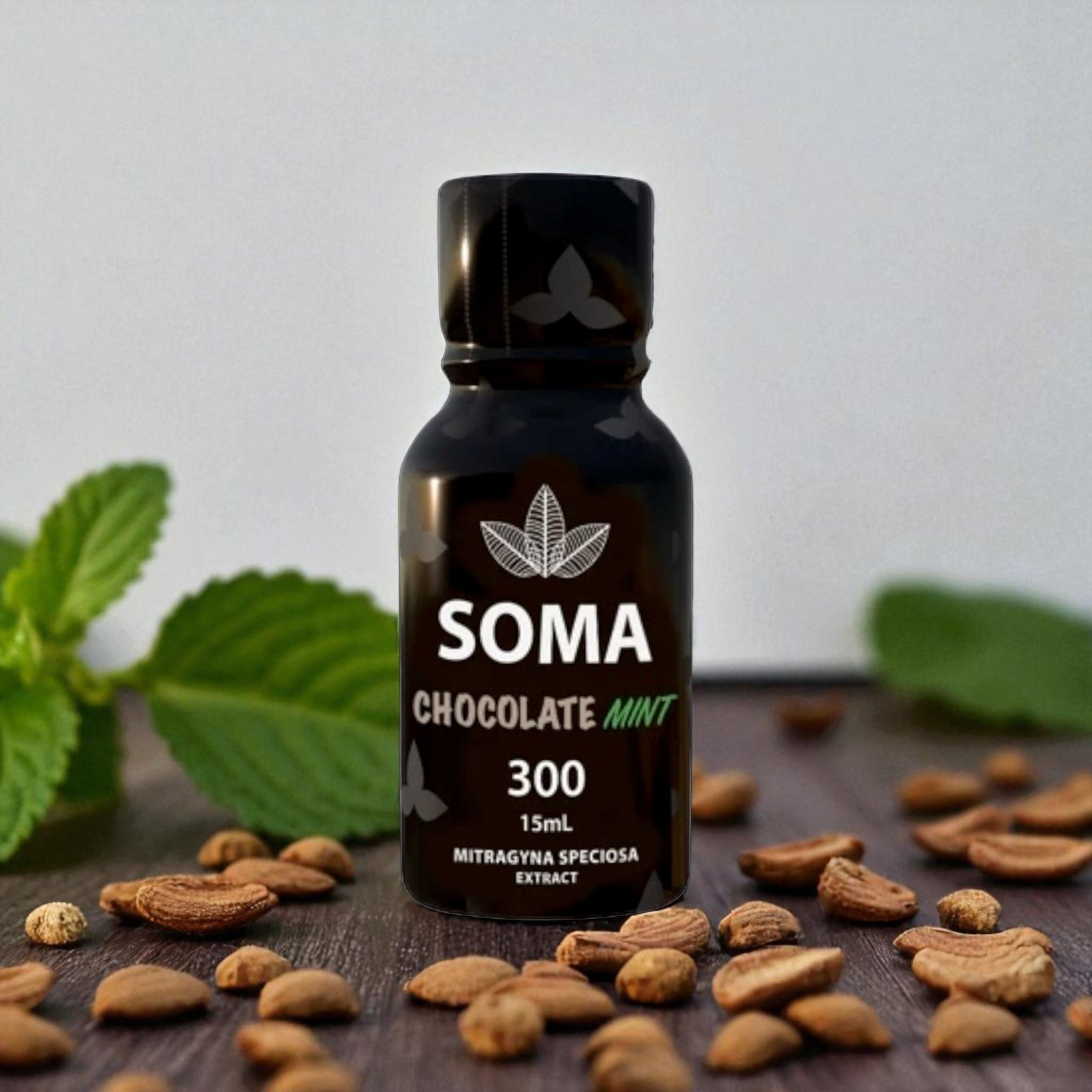 Bottle of SOMA chocolate extract with cocoa beans and mint leaves.
