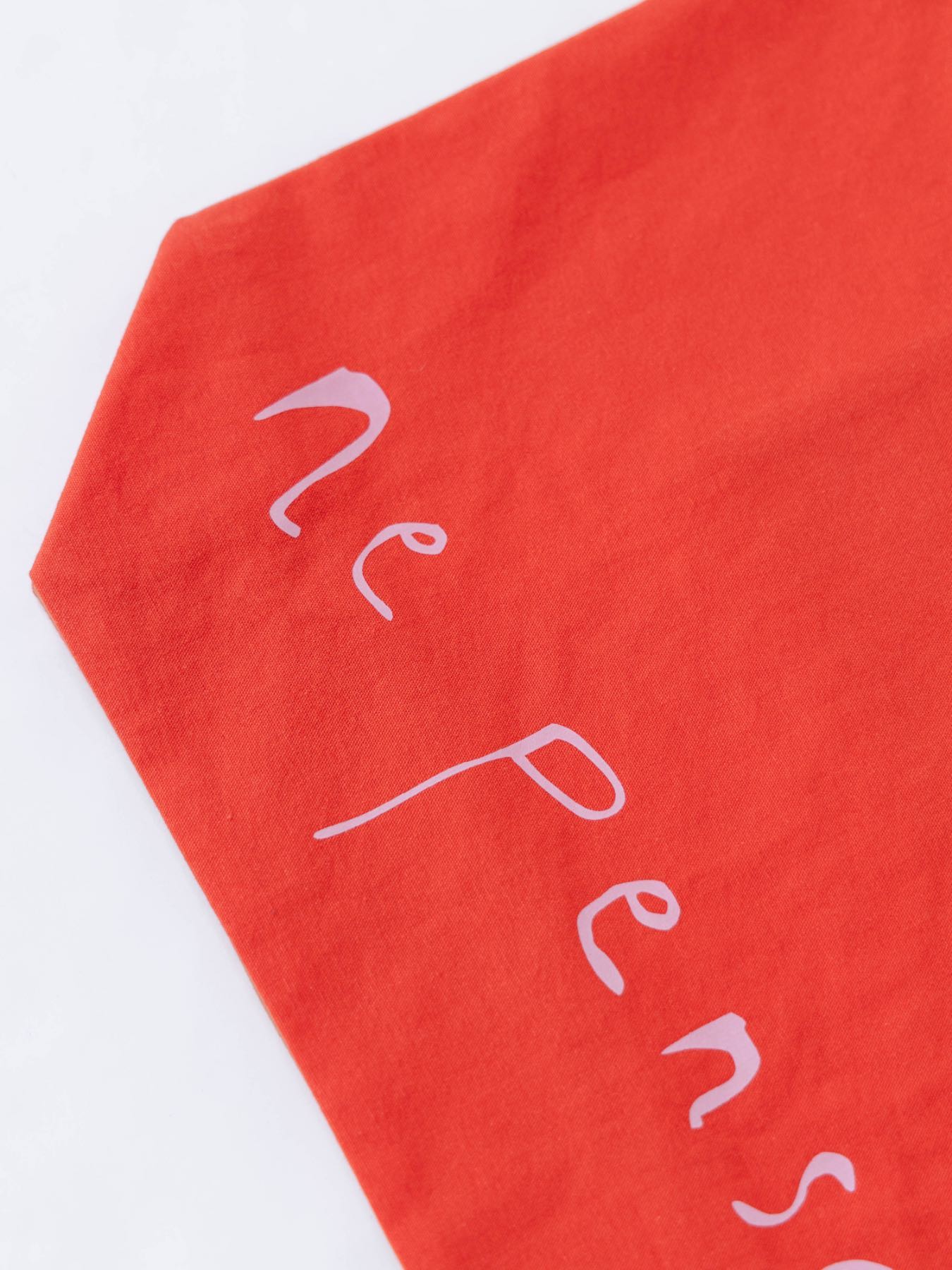 Red fabric with white handwritten text reading 