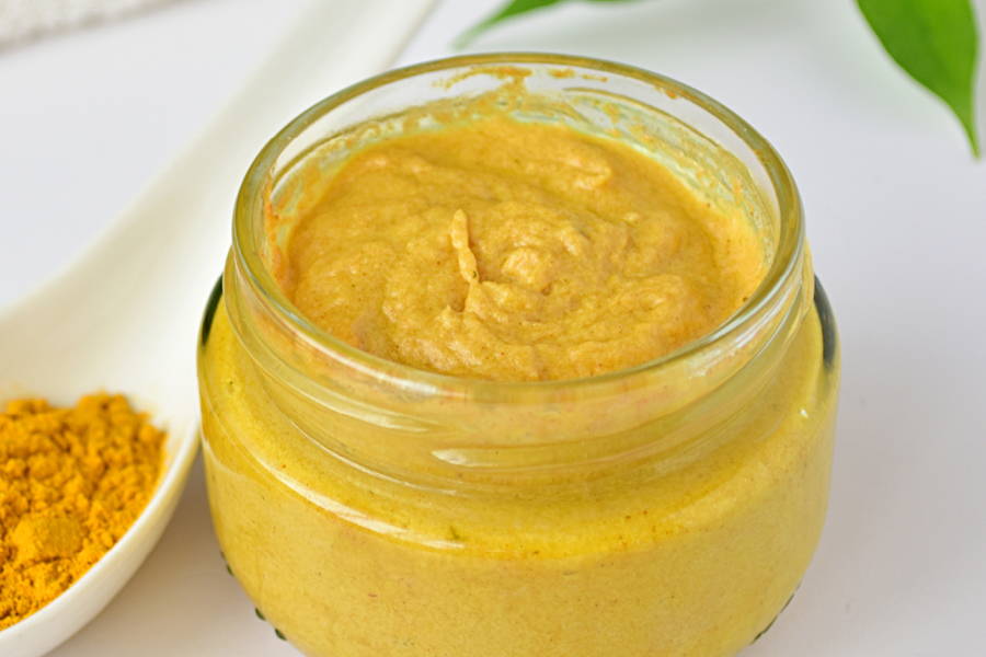 jar of yellow paste with turmeric powder