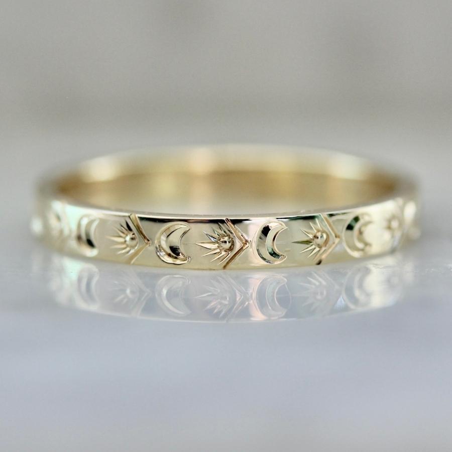 Hand-engraved wedding band with suns and moons
