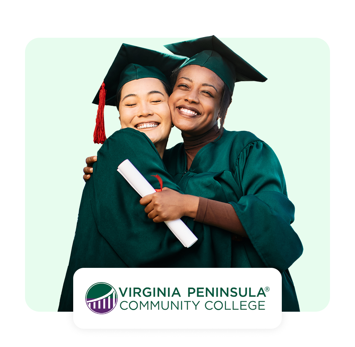 Two graduates in caps and gowns embracing, celebrating their achievement.