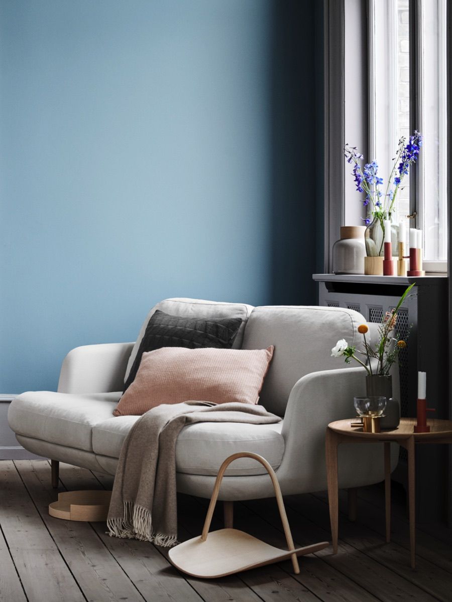 Cozy living room with a Lune sofa by Fritz Hansen, pillows, and decorative flowers.