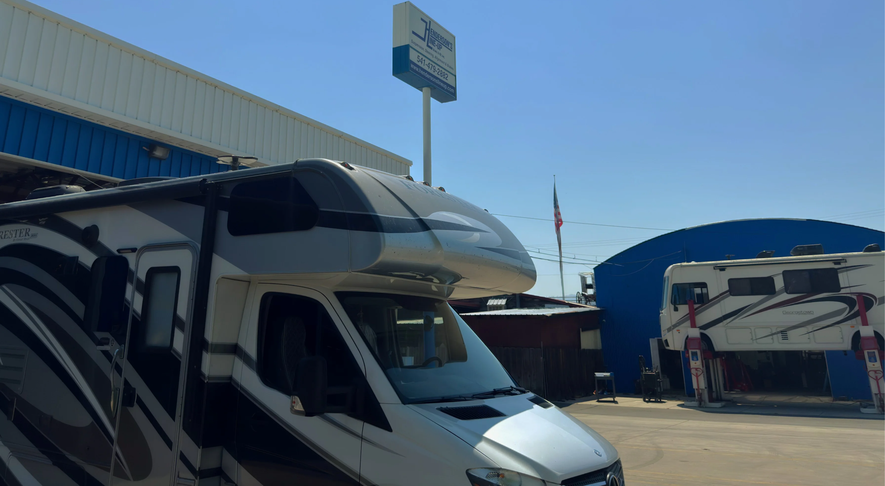 RV parked in front of a building under a clear blue sky.