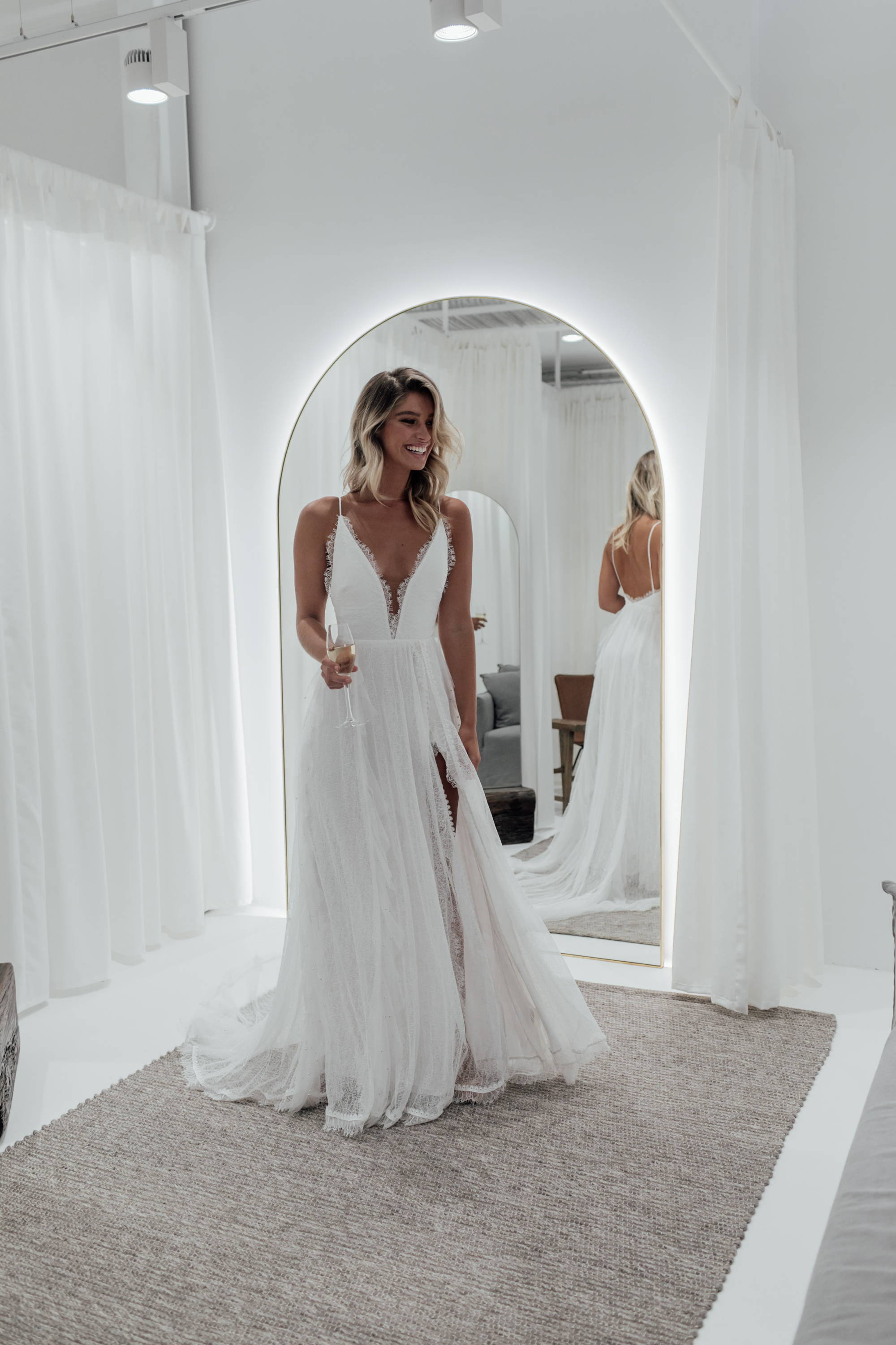Bride in white wash dressing room wearing the Grace Loves Lace Song wedding dress