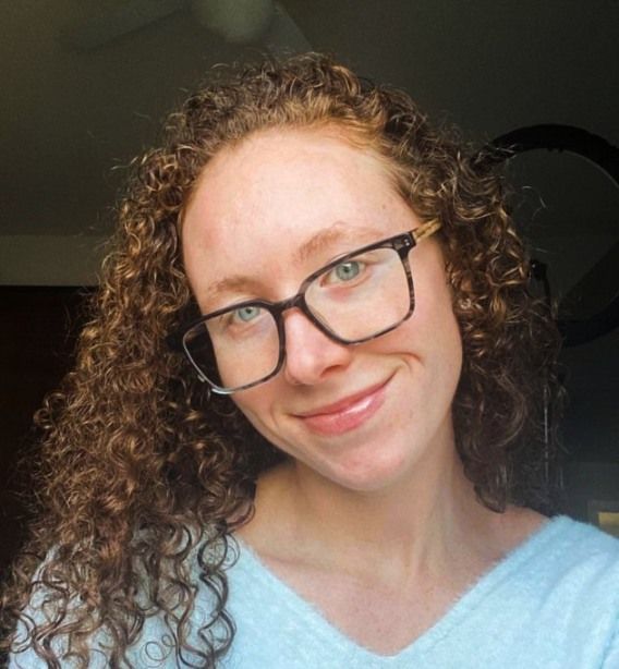 woman with greenish blue eyes wearing Trust Grey eyeglasses