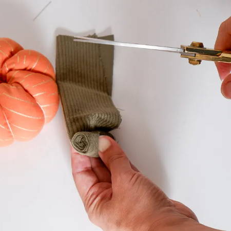 Hands rolling up the fabric strip and cutting the excess fabric off