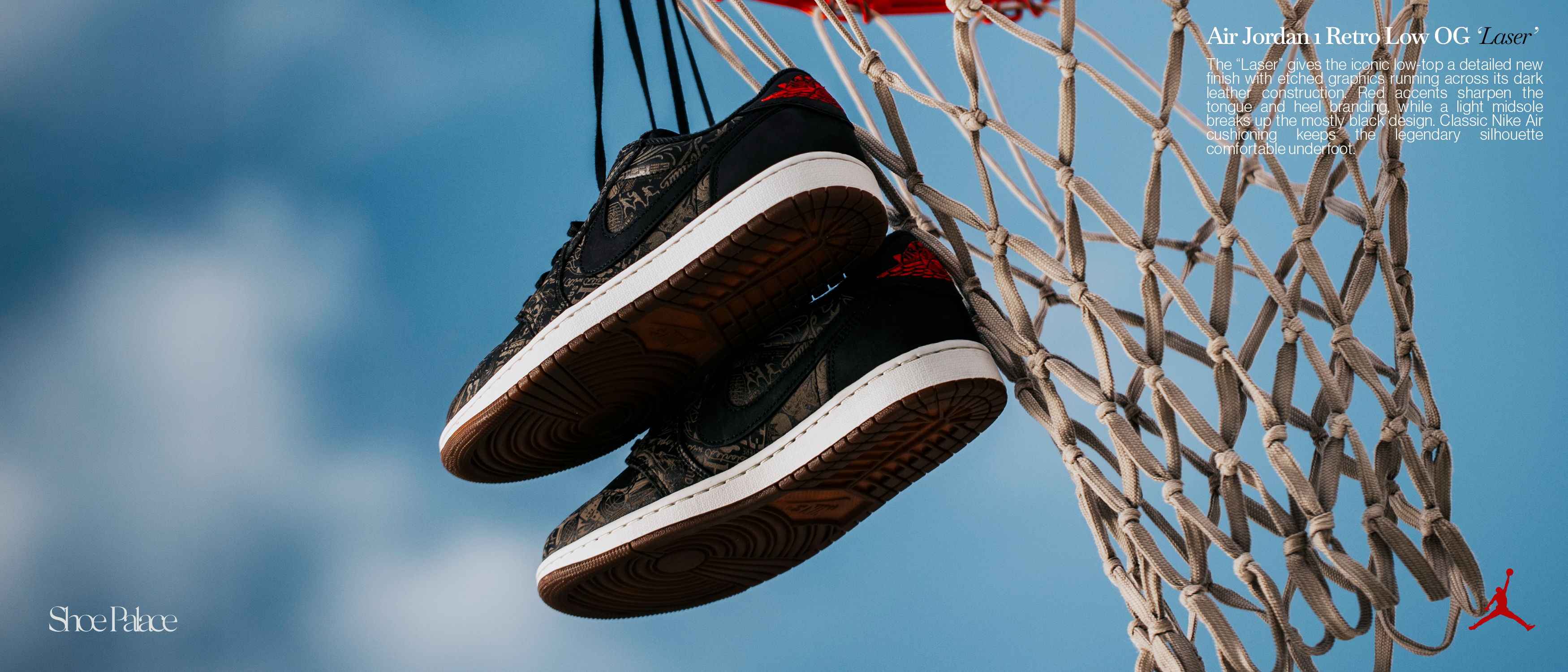 A pair of sneakers hanging from a basketball net against a blue sky.