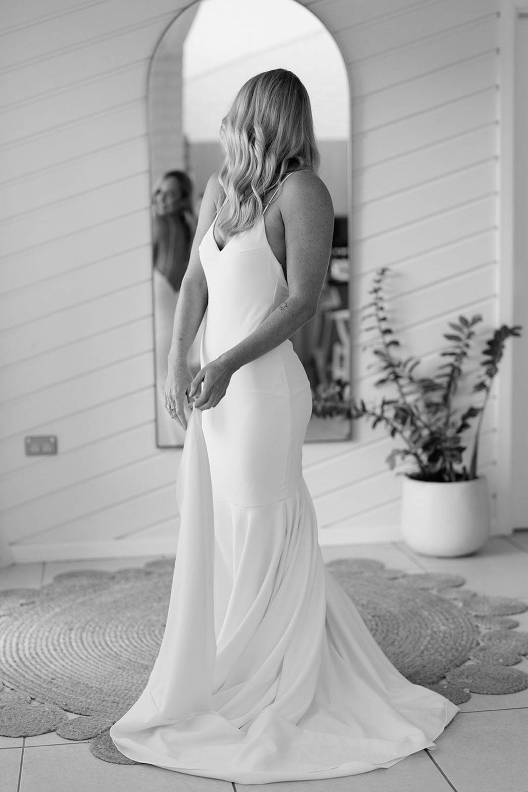 Bride, looking at herself in the mirror, wearing the Clo Crepe