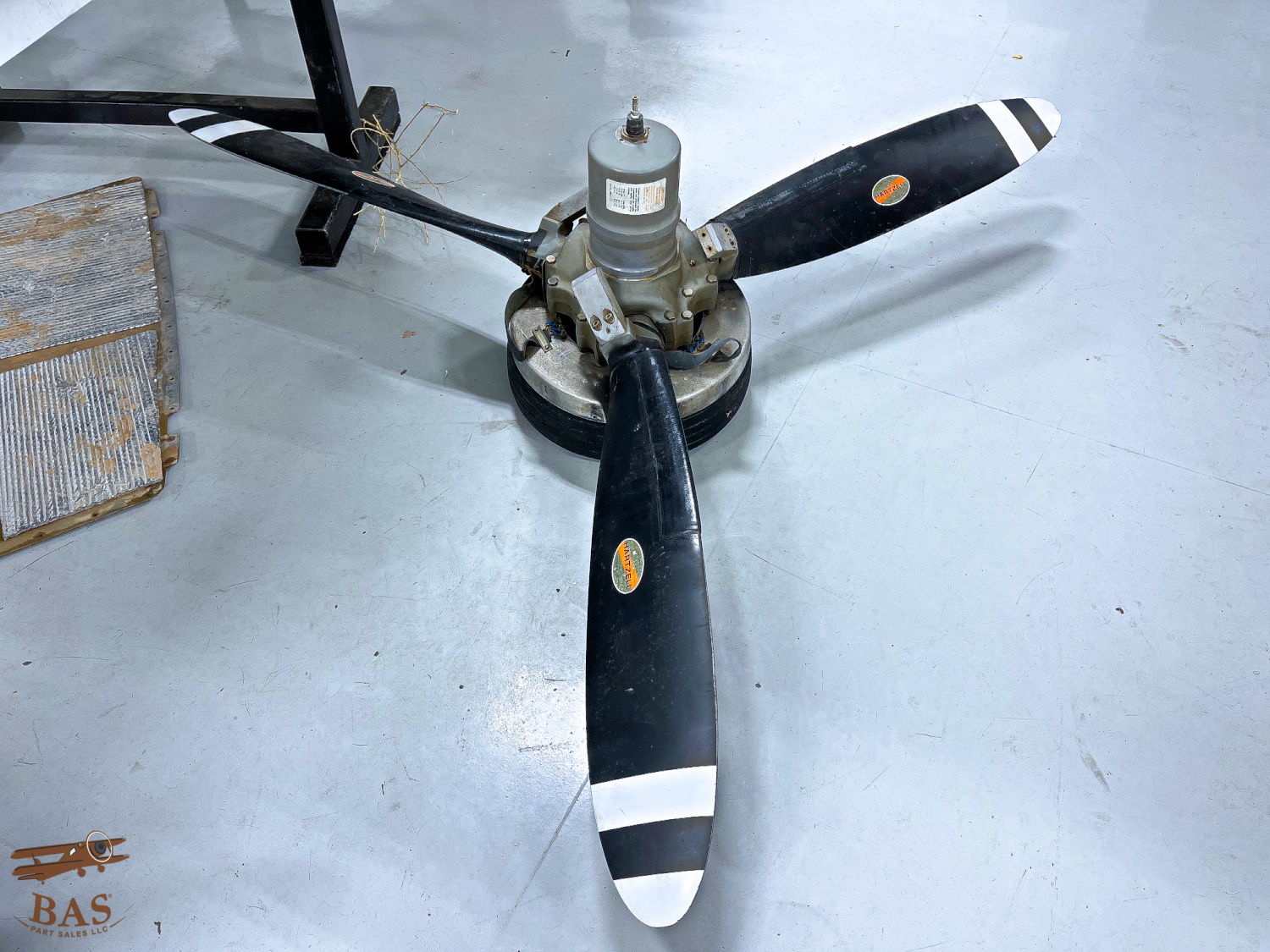 Propeller with three blades mounted on a base.
