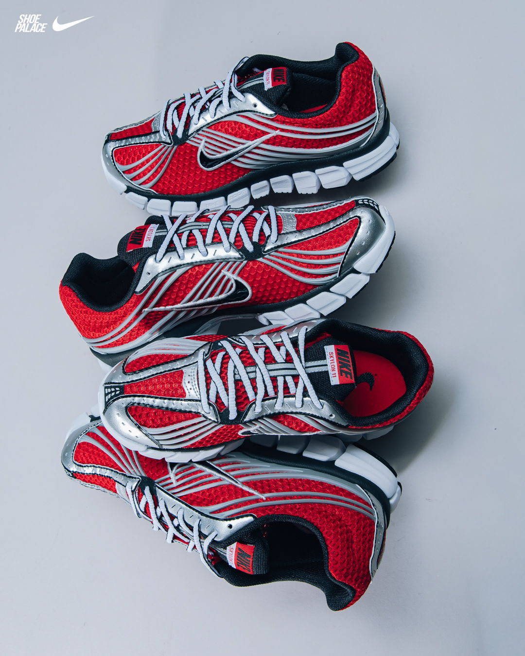 Red and silver Nike sneakers stacked on a gray background.