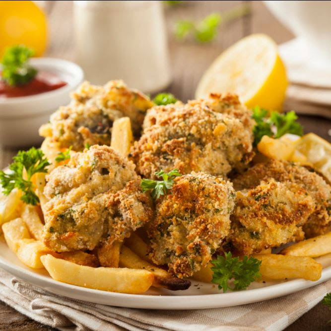 fried oysters with parsley and french fries on a plate